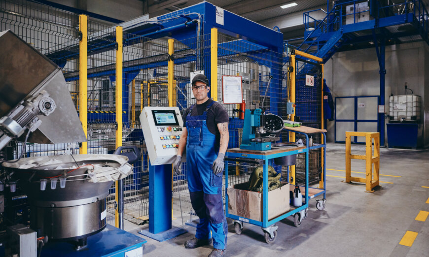 Moll Rail Mitarbeiter steht vor Bedienfeld der Produktion Moll Rail Mitarbeiter steht vor Bedienfeld der Produktion
